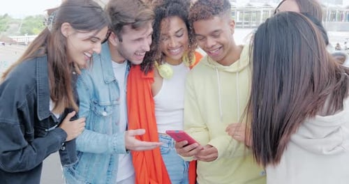 Friends Laughing Together at Phone Screen Outdoors