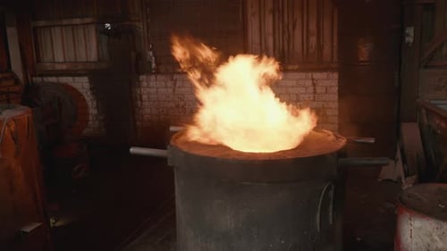 Slow motion orbit of hot flames blazing furnace in rustic foundry workshop