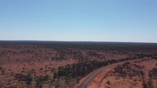 Drone ascending them moving forward over a sealed country road in the Australian Outback