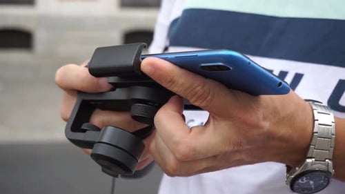 Close up shot of man putting cell phone into gimbal
