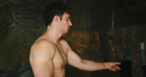 Shirtless Man Turns on Shower in Stone Bathroom