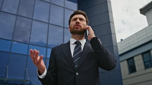 Bearded Businessman Talking Cellphone in Front Modern Office Building Closeup