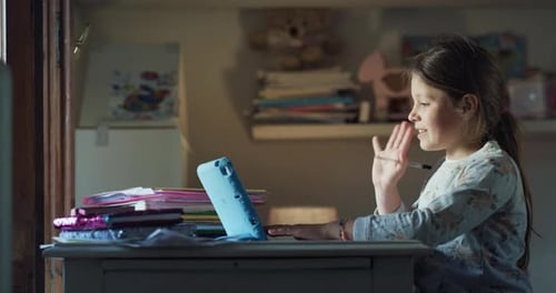 Girl Using Tablet for Homework in Bedroom