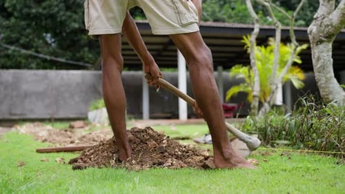A Black Man is Digging a Hole in the Ground in His Garden Closeup Slow Motion
