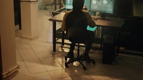 Silhouette d'un pirate informatique codant pour implanter un virus de Troie