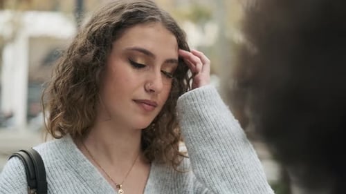 Happy Woman Talking with a Friend in the Street