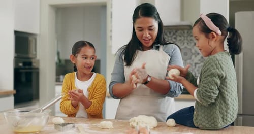 Mother and Daughters Baking Dough in Kitchen