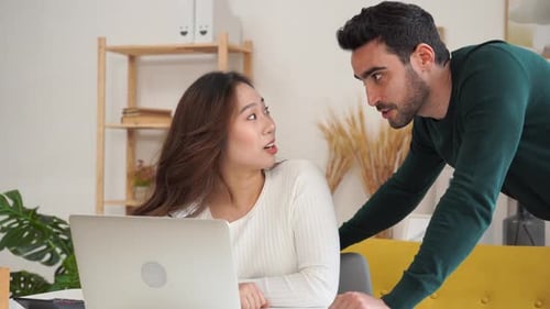 Woman and Man Discuss Project on Laptop