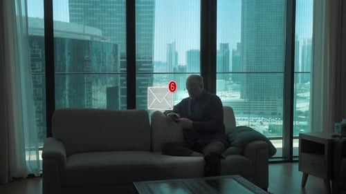 Man Uses Phone on Couch Overlooking City