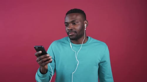 Man Puts in Headphones and Listens to Music