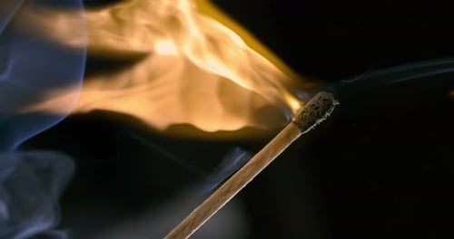 Burning matchstick close-up on a dark background. Shot on super slow motion camera 1000 fps.