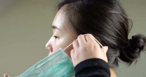 Asian Woman Putting On Face Mask In Slow Motion