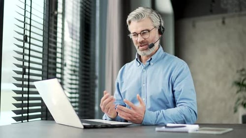 Man Speaking on Laptop Video Conference in Office