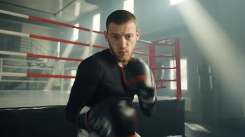 Medium Shot of Young Handsome Boxer Performing Shadow Boxing in Gym