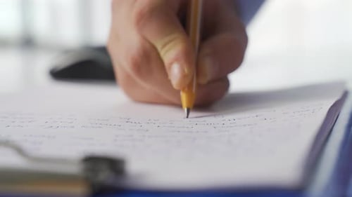 Hand Writing Notes on Paper with Yellow Pen