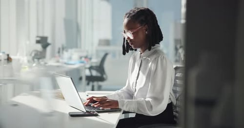 Professional Woman Works on Laptop in Modern Office
