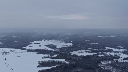 Aerial Drone View of Snow-Covered Winter Landscape Under Overcast Skies