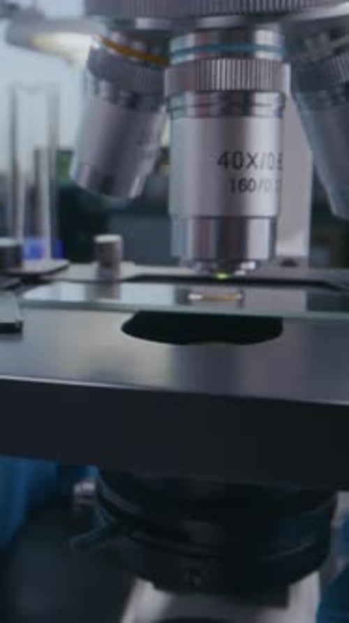 Close Up of Professional Microbiologist Setting Up Microscope for Analysis
