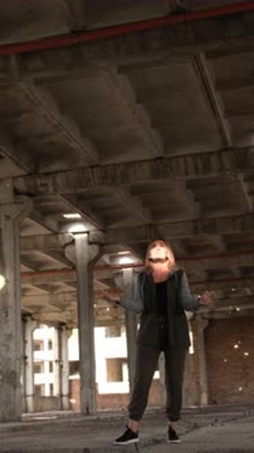 Masked Man Gesturing in Dark Building with Hardwood Flooring