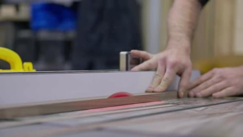 Man cuts wood on a table saw in his shop
