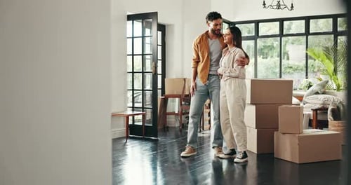 Young Couple Embracing in New Home with Boxes