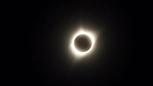 Die Sonnenkorona bewegt sich während einer totalen Sonnenfinsternis über den Himmel.