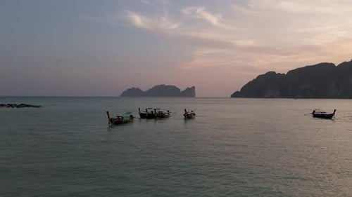 Drone Aerial view flying over longtail boats during sunset at Koh Phi Phi