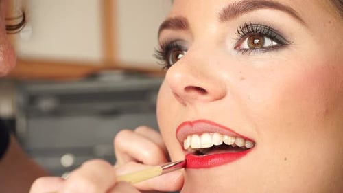 Makeup Artist Applying Red Lipstick To Model Lips