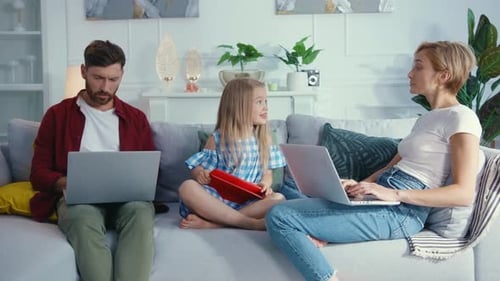 Family Uses Technology on Couch in Living Room