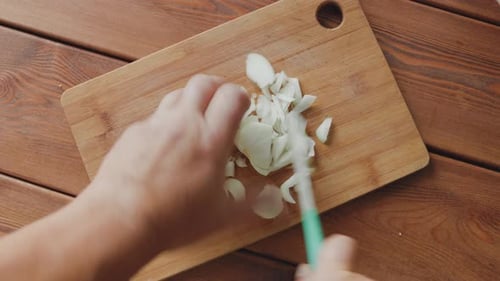 Male Hands with a Knife Cut Onion