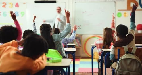 Teacher, students and classroom with hands raised for question, lesson or engagement in school