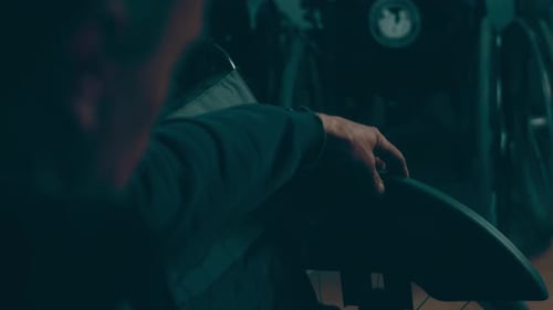 Adult's Hand Resting on Black Wheelchair Armrest