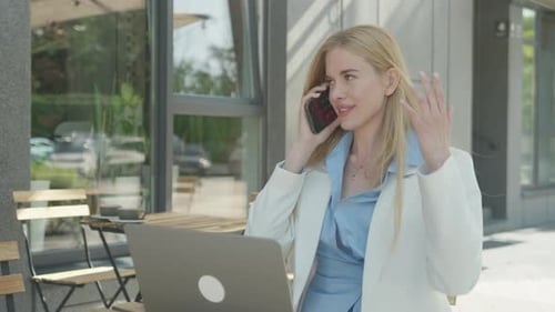 Confident Businesswoman Talking On Smartphone While Working At Outdoor Cafe
