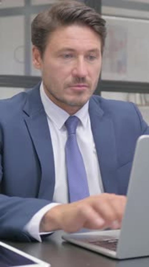 Man Working on Laptop in Office Environment