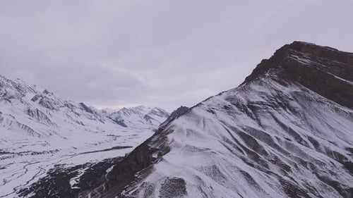 Blick auf die verschneite Landschaft mit schroffen Bergwegen