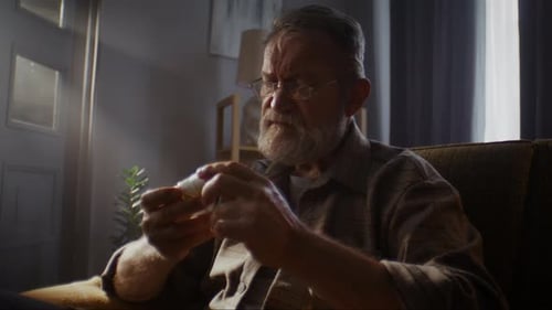 Adult Examines Prescription Medication Bottle in Home