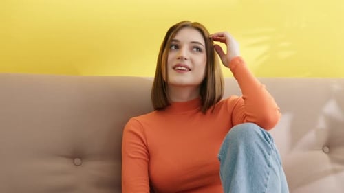 Young Woman Smiling and Sitting on a Couch