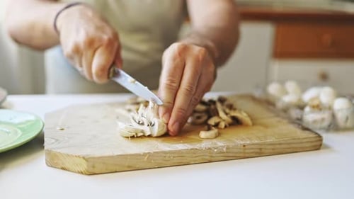 Man Slicing Fresh Mushrooms on a Cutting Board