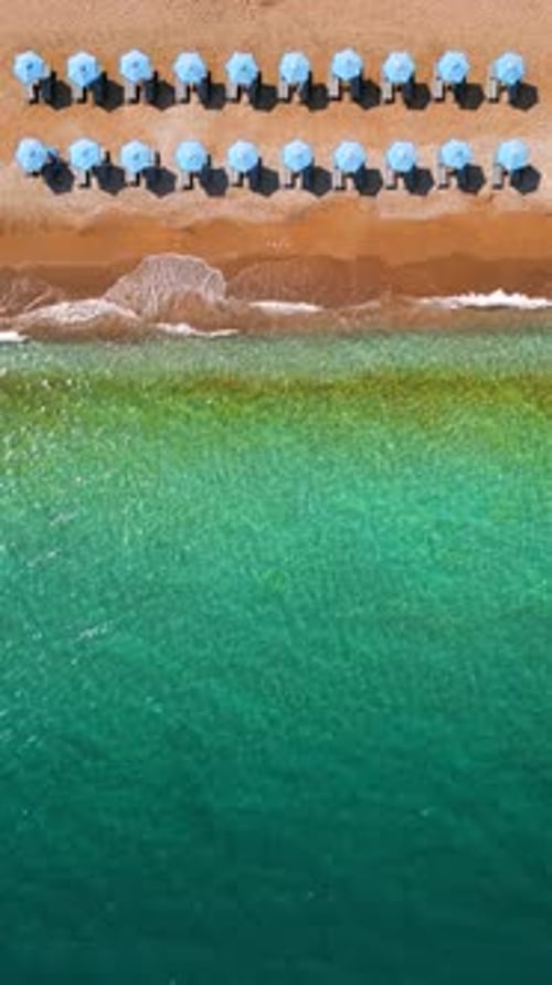 Topdown View of Sandy Beach with Sun Umbrellas and Turquoise Sea Water
