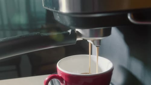 Pouring Coffee Stream From Machine in Red Cup