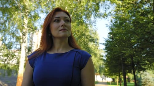 Portrait of Gorgeous Redhead Mature Woman Strolling in Public Park