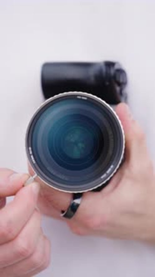 Vertical - person hold camera with variable nd filter and adjust light intensity