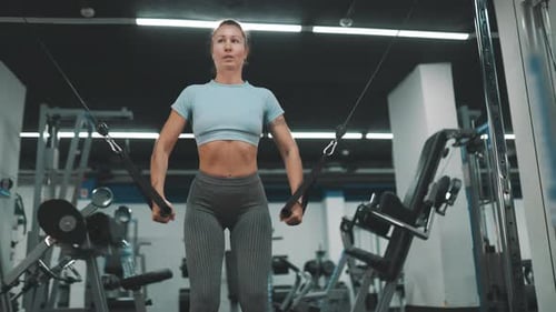 Athletic Woman Training Chest on Cable Crossover Machine