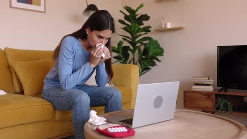 Woman Coughs While Using Laptop at Home