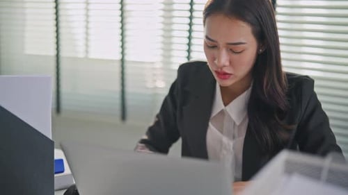 Frustrated Asian young businesswoman overwork late in office workplace