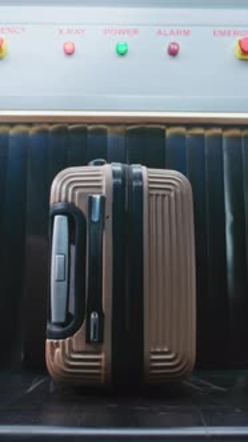 Security Check in Airport Passenger Places Suitcase on Conveyor Belt for Baggage Screening