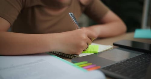 Person Writing in a Notebook with Pen Close Up