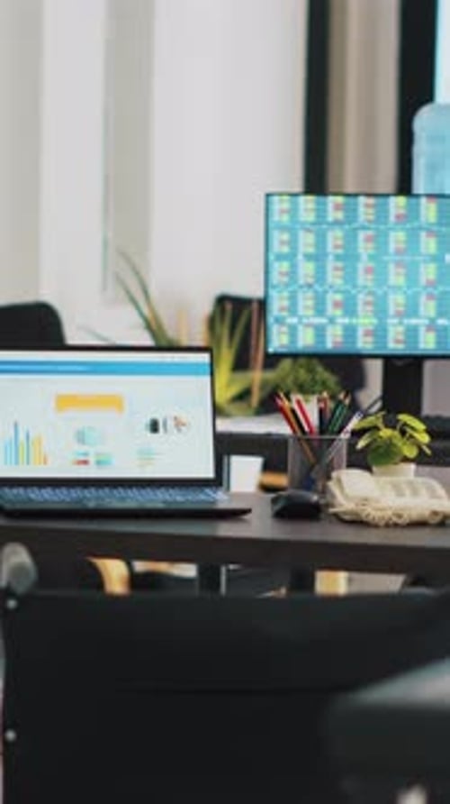 Vertical Video Company Workspace with Nobody in and Business Figures on Computer Monitors