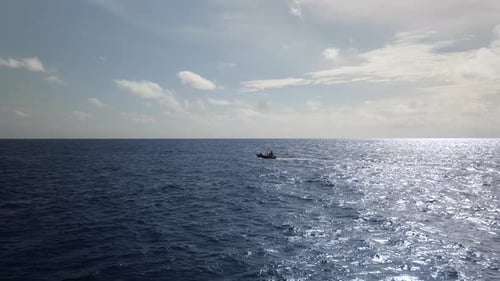 Motorboat driving in sun reflecting on the open ocean in 4k