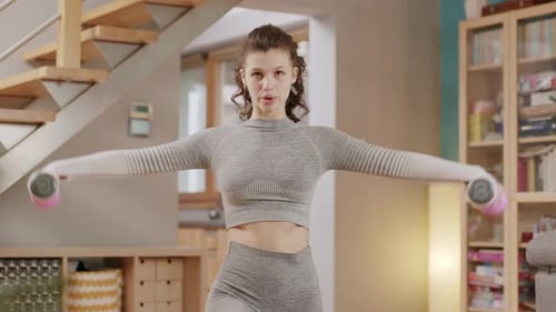 Woman Doing Arm Raises with Dumbbells at Home